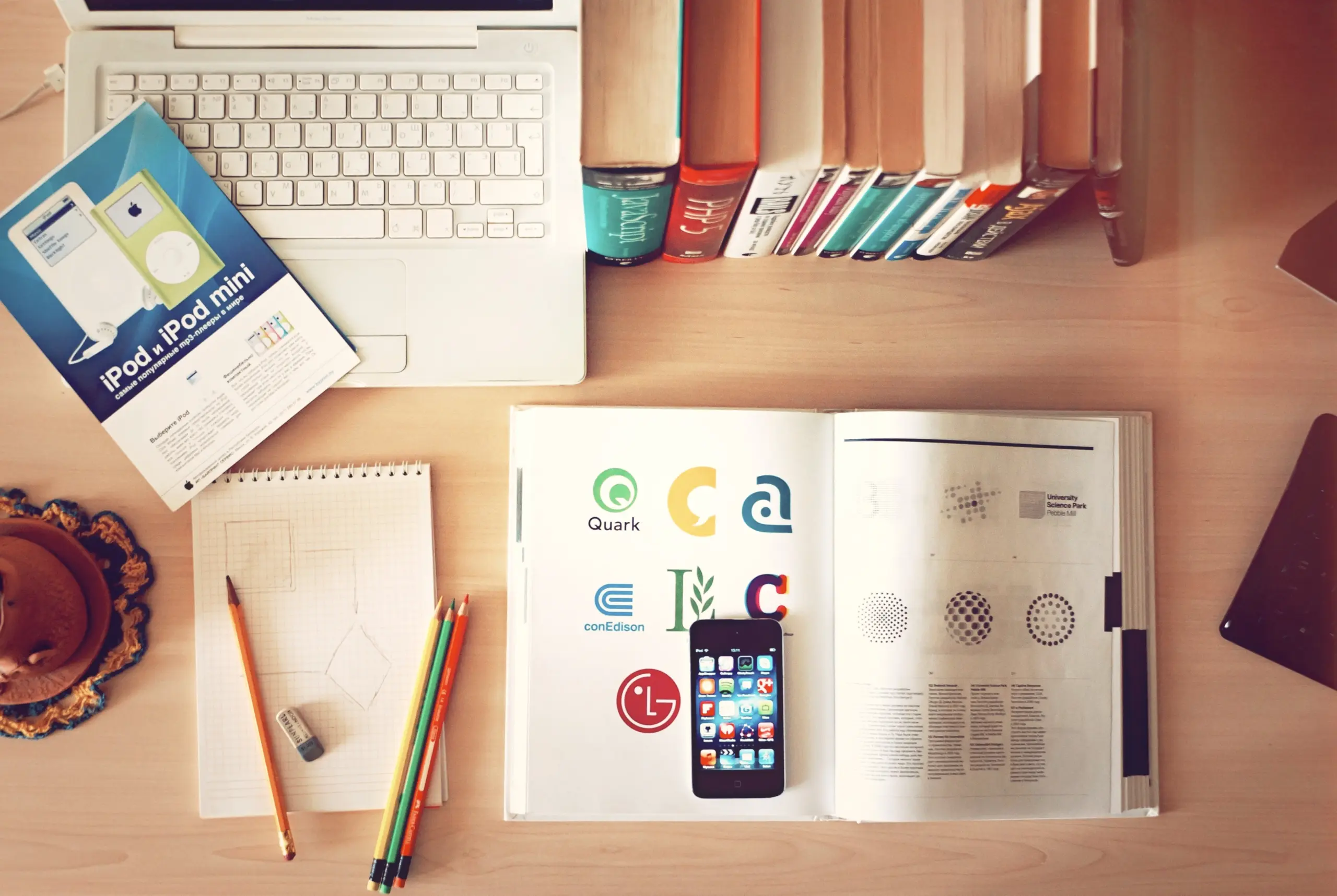 Top-down view of books, pencils, laptop, and phone on a desk